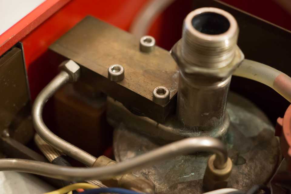 The black heat exchanger gasket peeks out between the brass block and the top of the boiler.